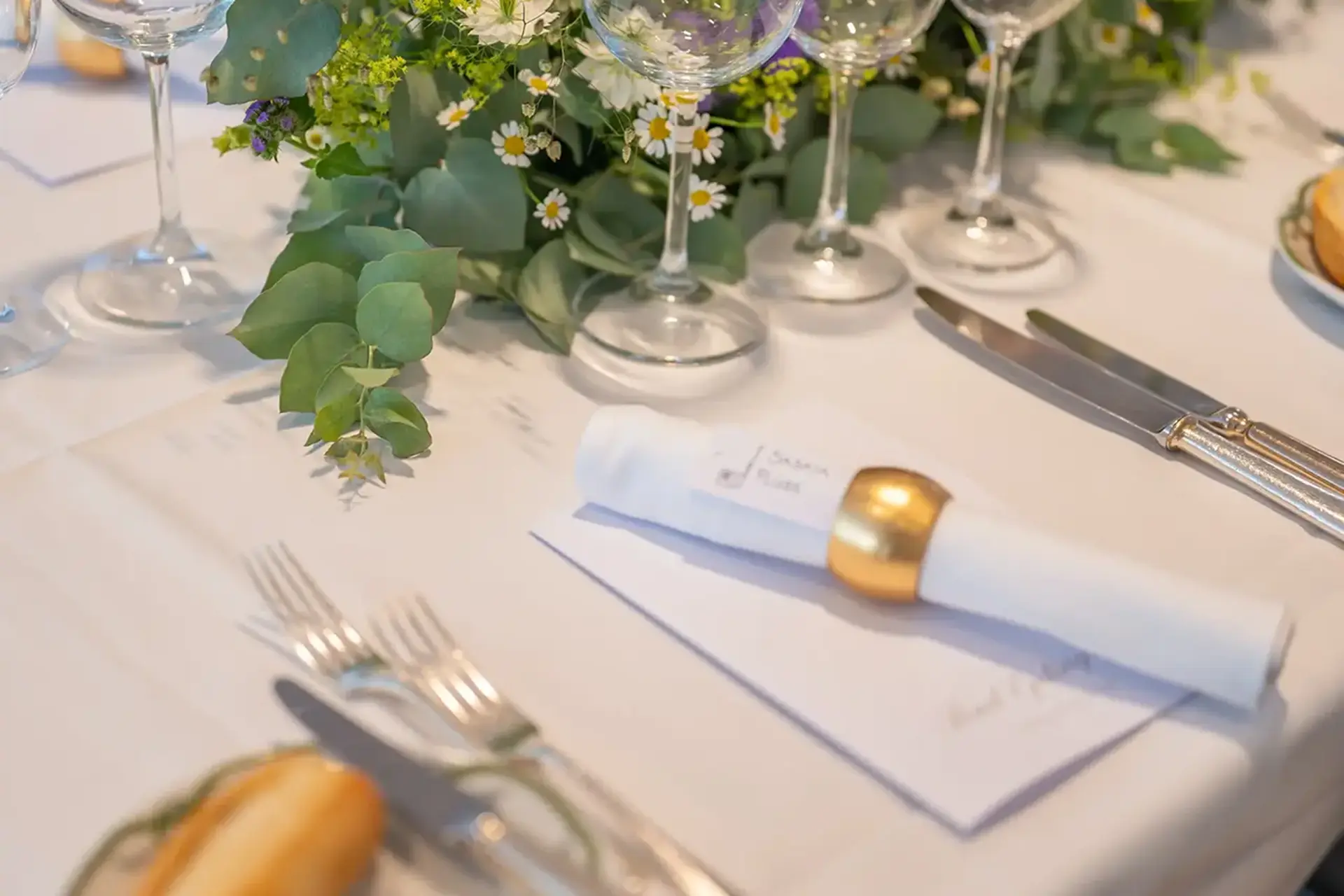 Stilvoll gedeckter Restauranttisch mit Kerzen und Blumenschmuck