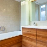 Badezimmer im Hotel Bad Eptingen mit Badewanne und hellen Natursteinfliesen
