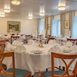Restaurant im Hotel Bad Eptingen mit Holzstuehlen und weissen Tischdecken