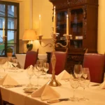 Gemuetlicher Kaminbereich im Hotel Bad Eptingen mit gedecktem Tisch im Vordergrund